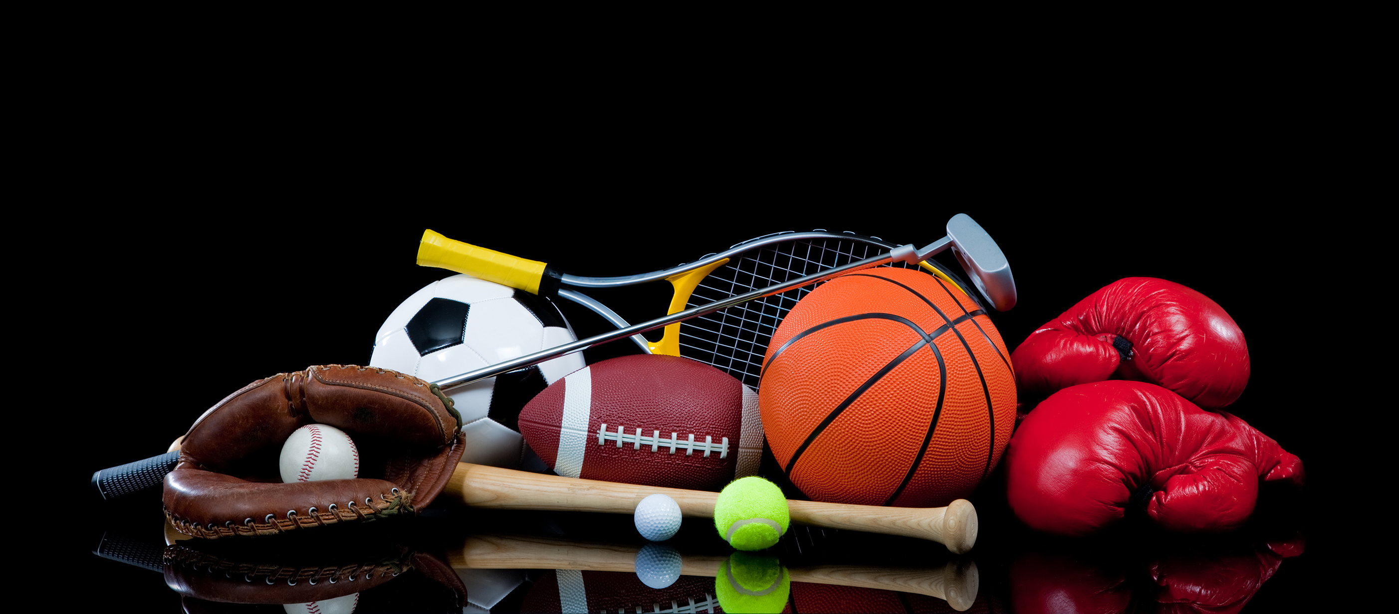 A group of sports equipment on black background including tennis, basketball, baseball, american fotball and soccer and boxing equipment