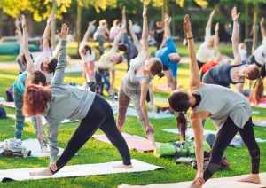 Image of a group of members participating in a yoga summer fitness challenge outside