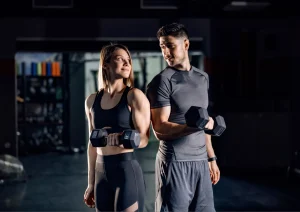 Image of two personal trainers in the gym looking at each other 