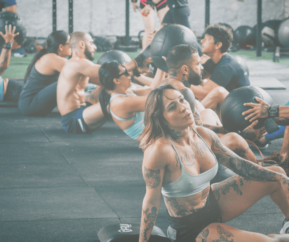Image of a group of people on the floor at a gym event workout