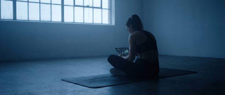 Image of woman in gym using a workout tracker