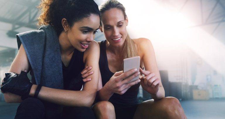 Image of a gym mobile app that is being used by woman in the gym