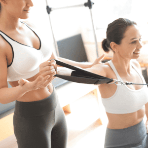 Image of a barre studio staff helping out a member