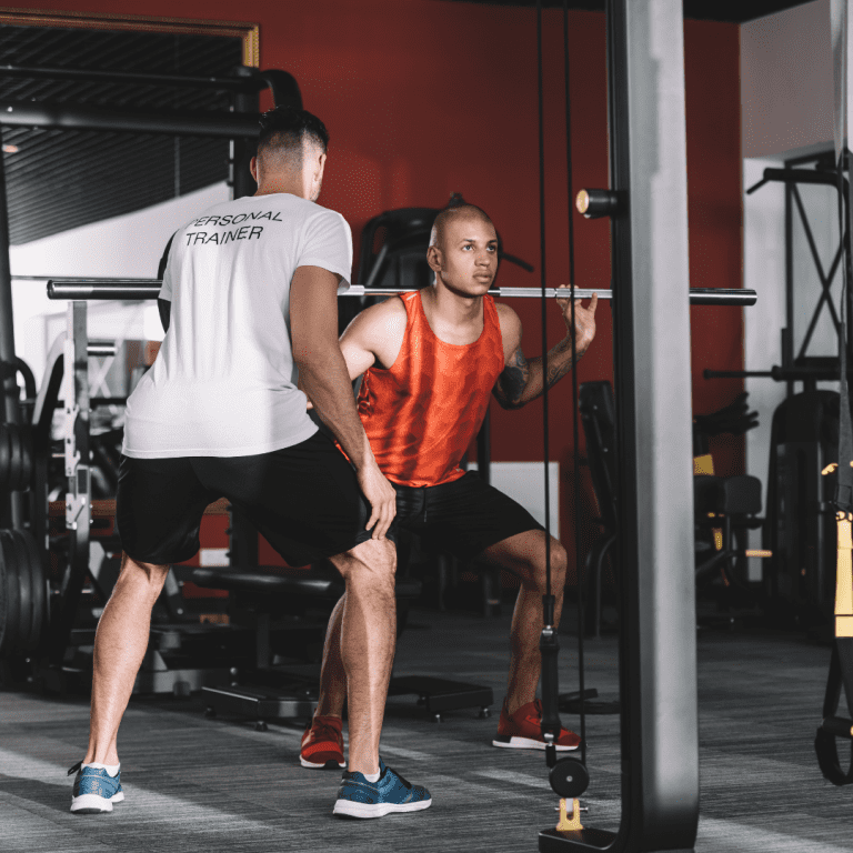 Image of personal trainer management walking through a squat exercise
